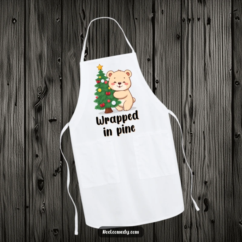 Funny apron depicting a cute bear cub hugging a decorated pine tree, ideal for festive kitchen activities.