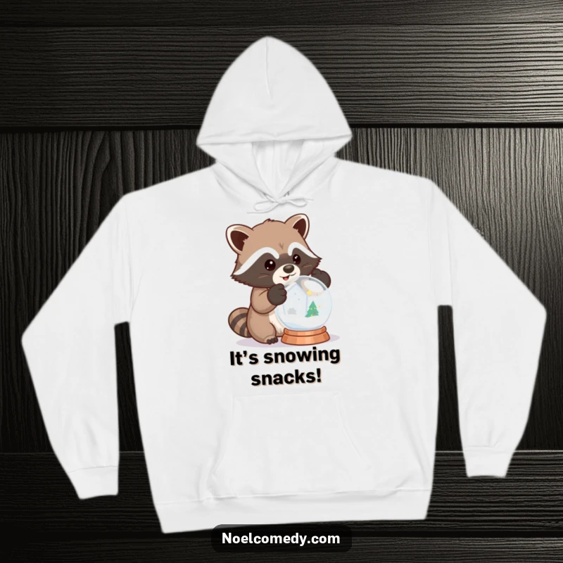 Funny hoodie design of a raccoon wearing mittens and shaking a snow globe with delight, perfect for winter.