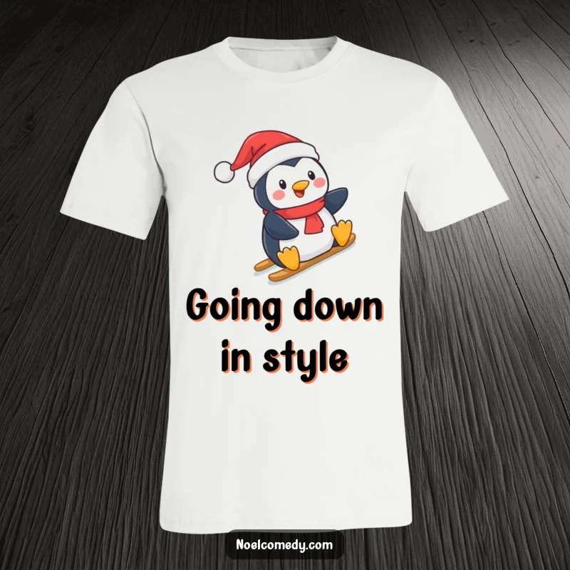 Funny T-Shirt: A happy penguin wearing a Santa hat, captured mid-slide down a snow-covered hill with excitement.