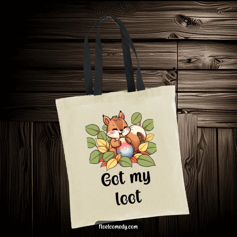 Funny Tote Bag showing a giggling squirrel hiding a shiny ornament among fallen leaves, perfect for holiday shopping.